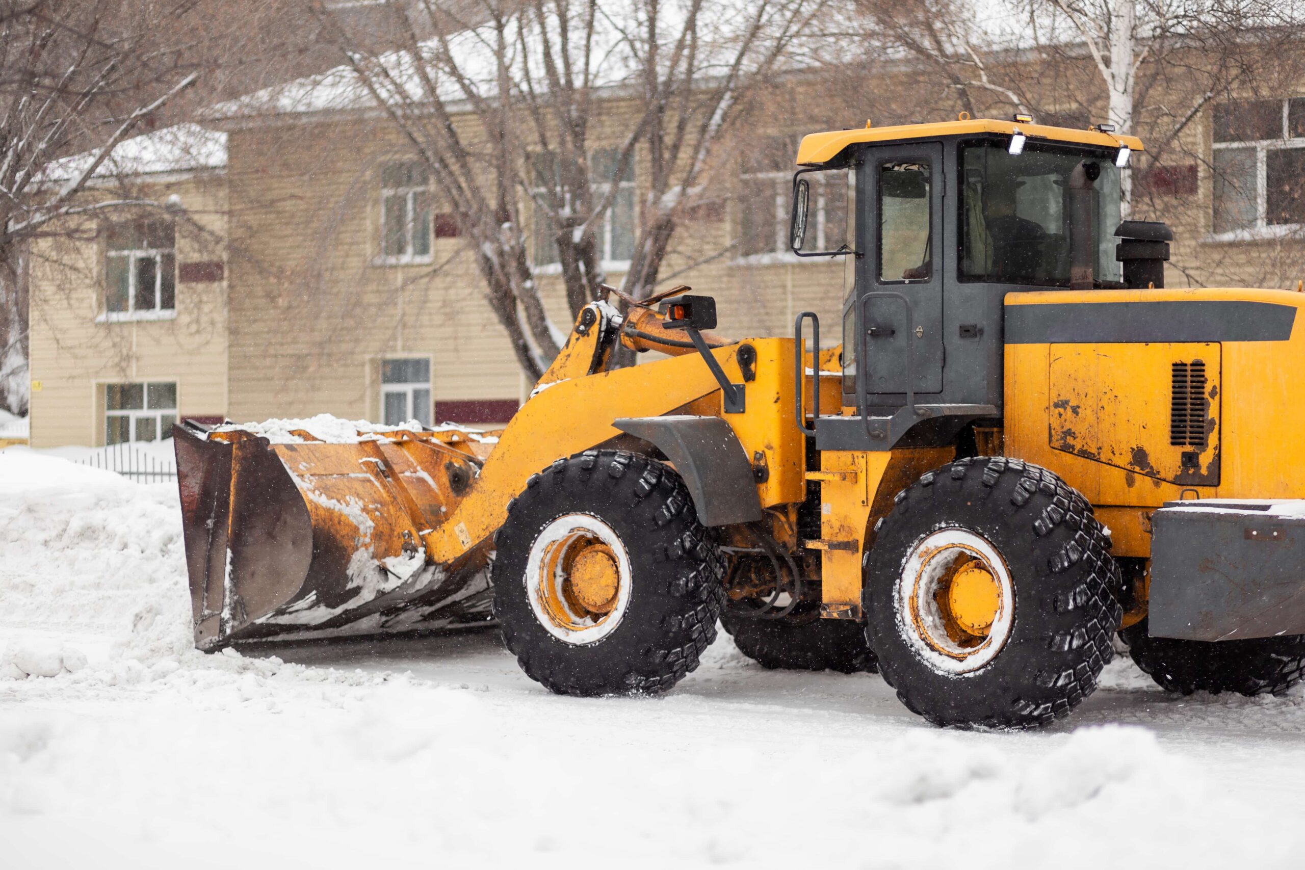 Snow plow at house clearing winter snow.