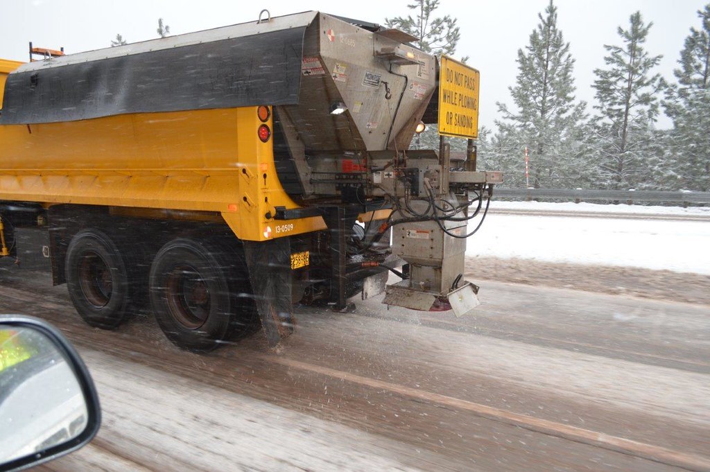 Truck salting snowy road.