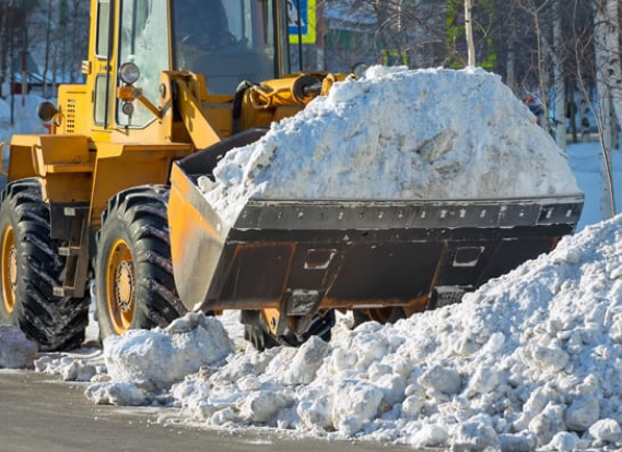 Snow removal tractor clearing snow to maintain accessibility